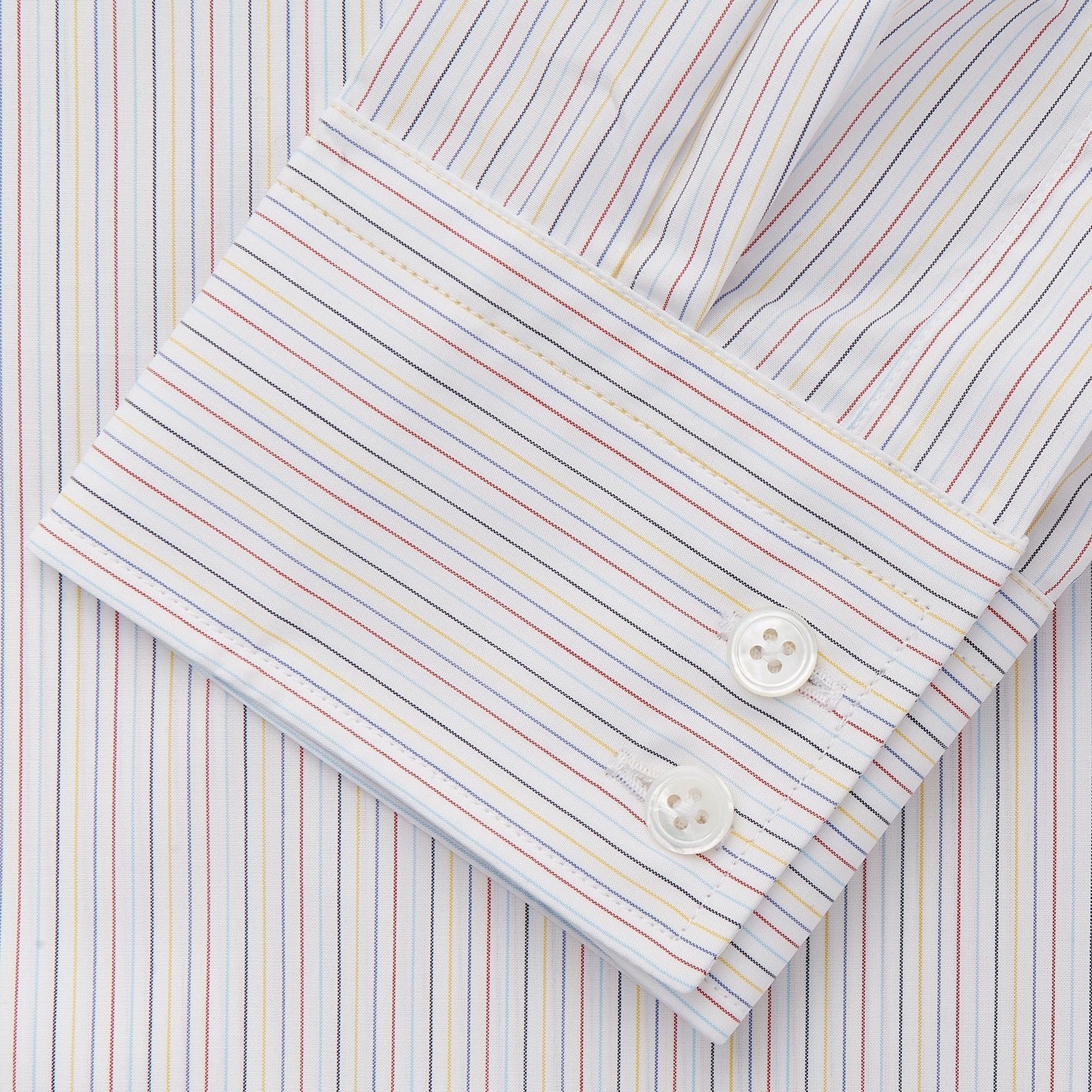 View 3 of product The Turnbull & Asser Red Multi Stripe Tailored Fit Shelton Shirt features subtle vertical stripes, a classic Kent collar, and buttoned cuffs, shown laid flat on a white background.