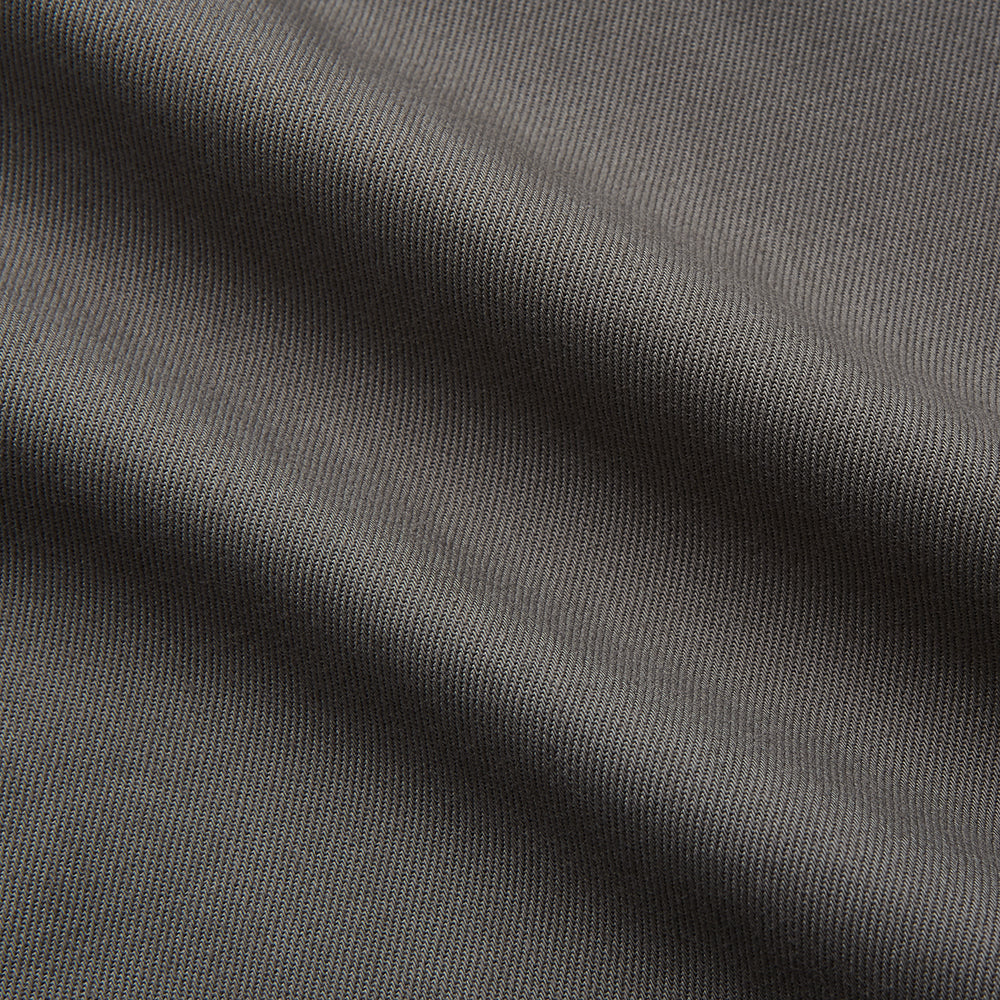 The Turnbull & Asser Dusty Sage Cotton Drill Weekend Fit Nevis Shirt features a button-down collar, long sleeves, two chest pockets, and white buttons, shown folded on a white background.