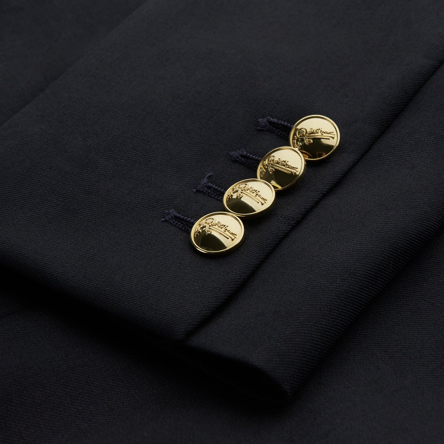 View 4 of product The Classic Navy Wool Blazer by Turnbull & Asser is a nautical double-breasted jacket with gold buttons, peaked lapels, three front pockets on one side, one on the other, and four gold buttons per cuff, shown against a white background.