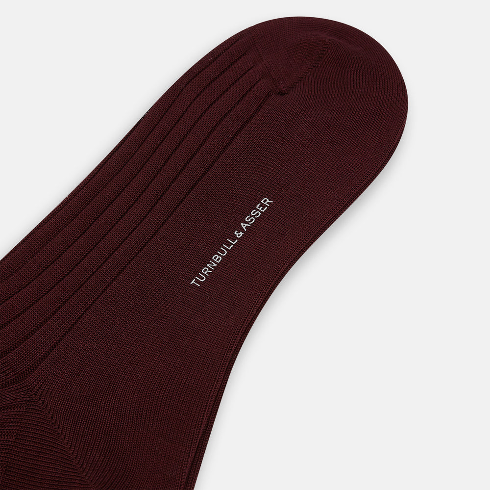 A single, burgundy thick knit mid-length sock from Turnbull & Asser is displayed upright on a plain white background.