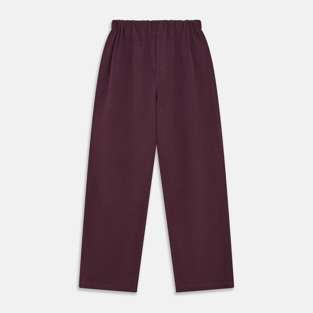 The Turnbull & Asser Plain Plum Silk Modern Pyjama Set, made in England, features white piping, a button-up long-sleeve top with three pockets, and matching pants. The pyjamas are shown against a white background.