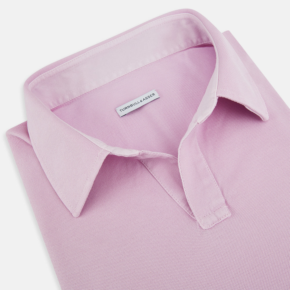 The Pink Rugby Polo Shirt by Turnbull & Asser features long sleeves, a collar, and V-neck opening in luxury cotton, shown flat on a white background.