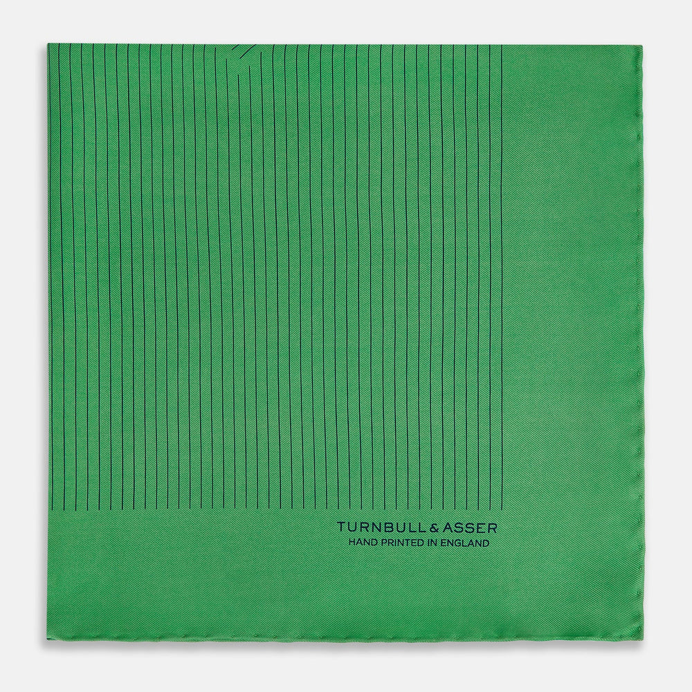 The Hunter Green Stripe Silk Pocket Square by Turnbull & Asser features thin black vertical stripes on one corner and “Turnbull & Asser Hand Printed in England” printed in black, reflecting classic British heritage.