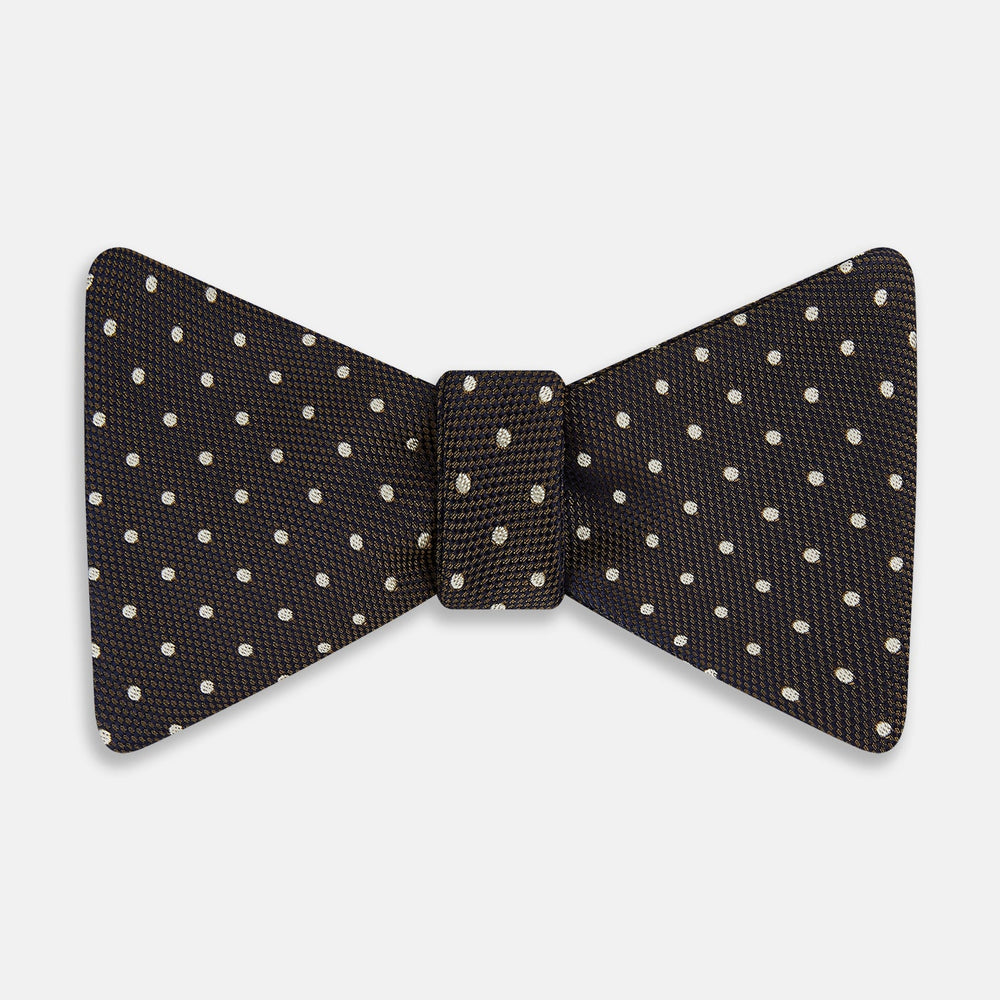 A stylish accessory, the White and Brown Micro Dot Silk Bow Tie by Turnbull & Asser features tiny brown dots on luxurious white silk, elegantly displayed against a plain white background.
