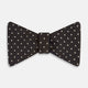 A stylish accessory, the White and Brown Micro Dot Silk Bow Tie by Turnbull & Asser features tiny brown dots on luxurious white silk, elegantly displayed against a plain white background.