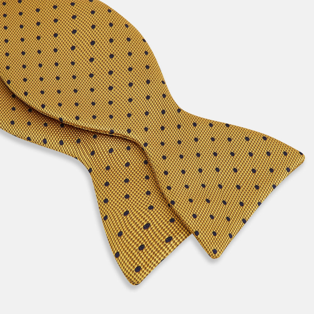 The Navy and Yellow Micro Dot Silk Bow Tie by Turnbull & Asser features a refined dot pattern—an ideal accessory for elevating sophisticated outfits.