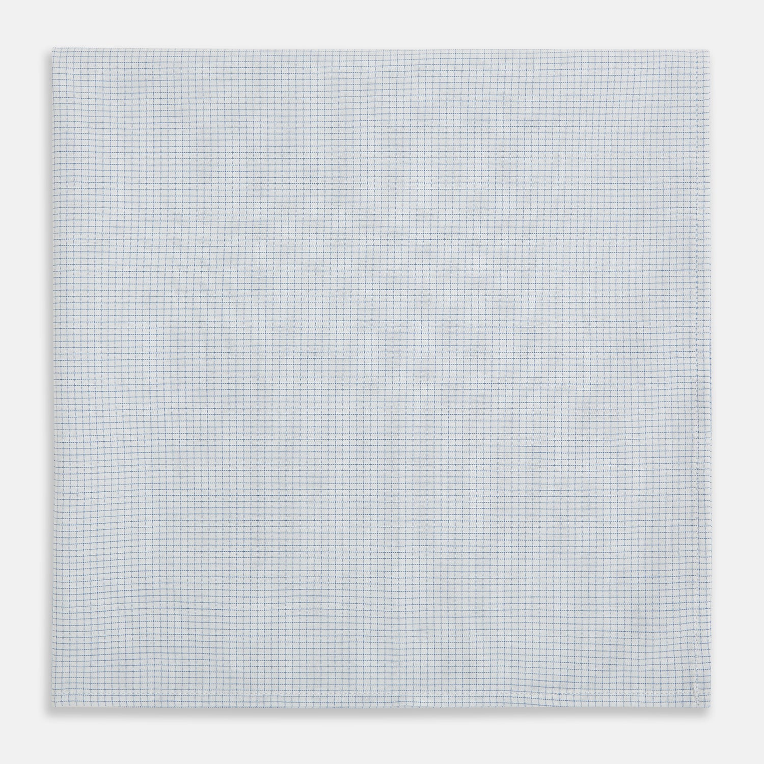 View 1 of product The Turnbull & Asser Hand Rolled Pale Blue Graph Check Handkerchief features a neatly folded white cotton design with a pale blue check, offering an elegant finishing touch to any setting.