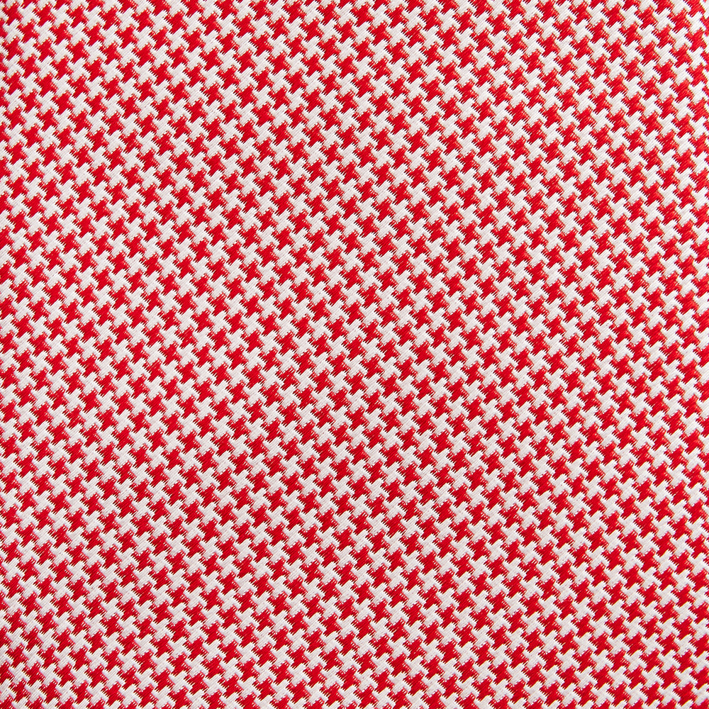 The Turnbull & Asser Red Houndstooth Silk Tie features a textured, small geometric pattern in red and white—ideal as a classic office accessory, shown rolled up on a plain white background.