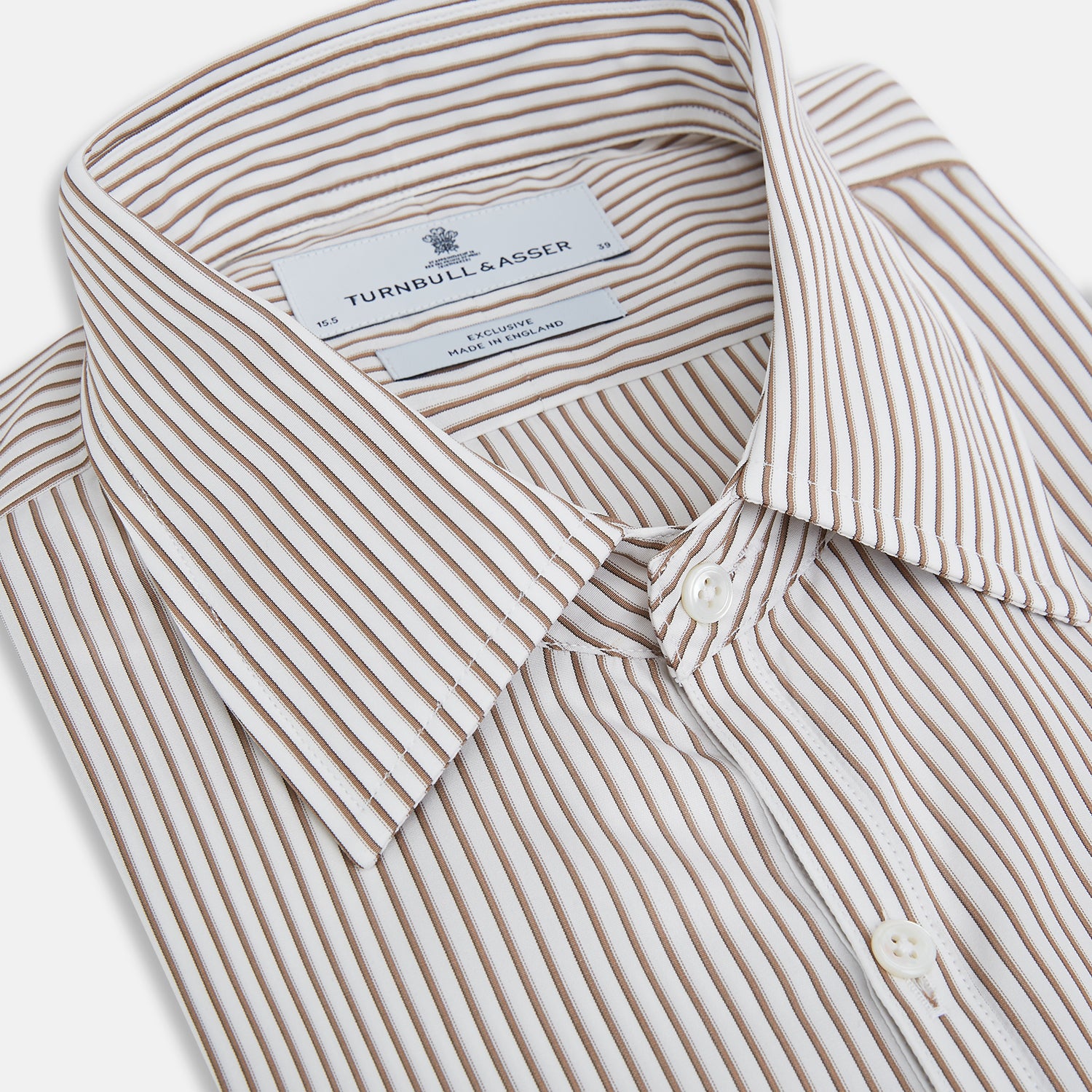View 2 of product The Turnbull & Asser Coffee Multi Stripe Westminster Shirt features long sleeves, a button-up front, subtle beige and white stripes, a pointed Turnbull collar, and buttoned cuffs—expertly crafted in Britain and shown flat on a white background.