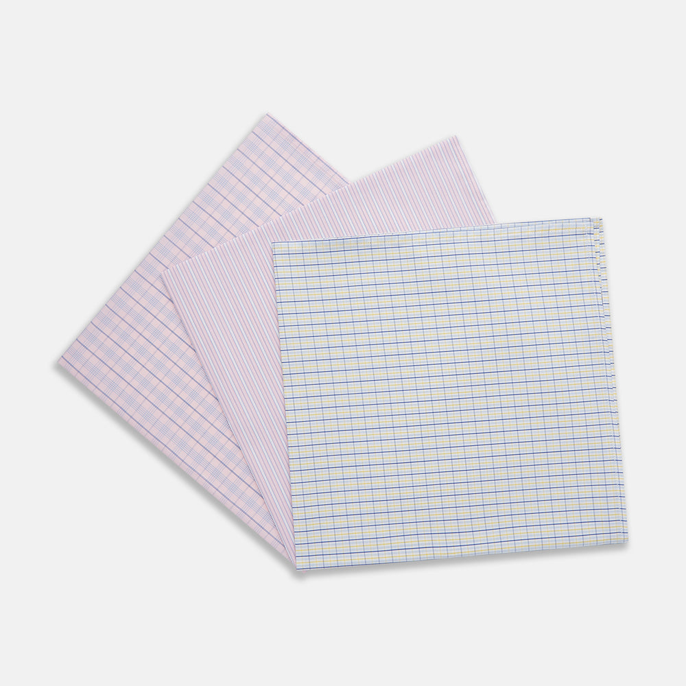 A neatly wrapped square gift box featuring Turnbull & Asser's Yellow and Red Cotton RE-PURPOSE Handkerchiefs 3-pack, tied with a matching plaid ribbon in a bow at the center, set against a white background.