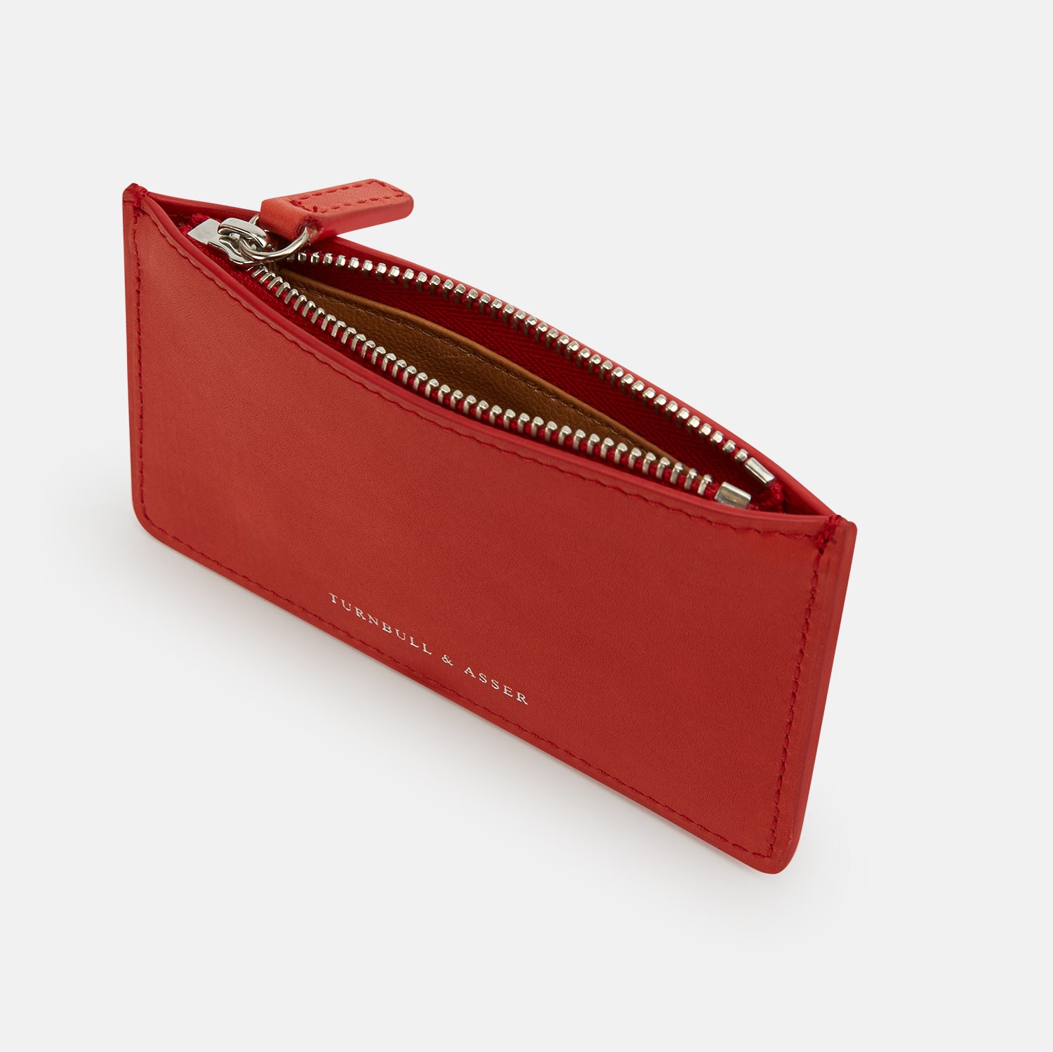 View 2 of product The Red Leather Zip Wallet by Turnbull & Asser features gold-embossed branding on the front and is shown against a plain white background.