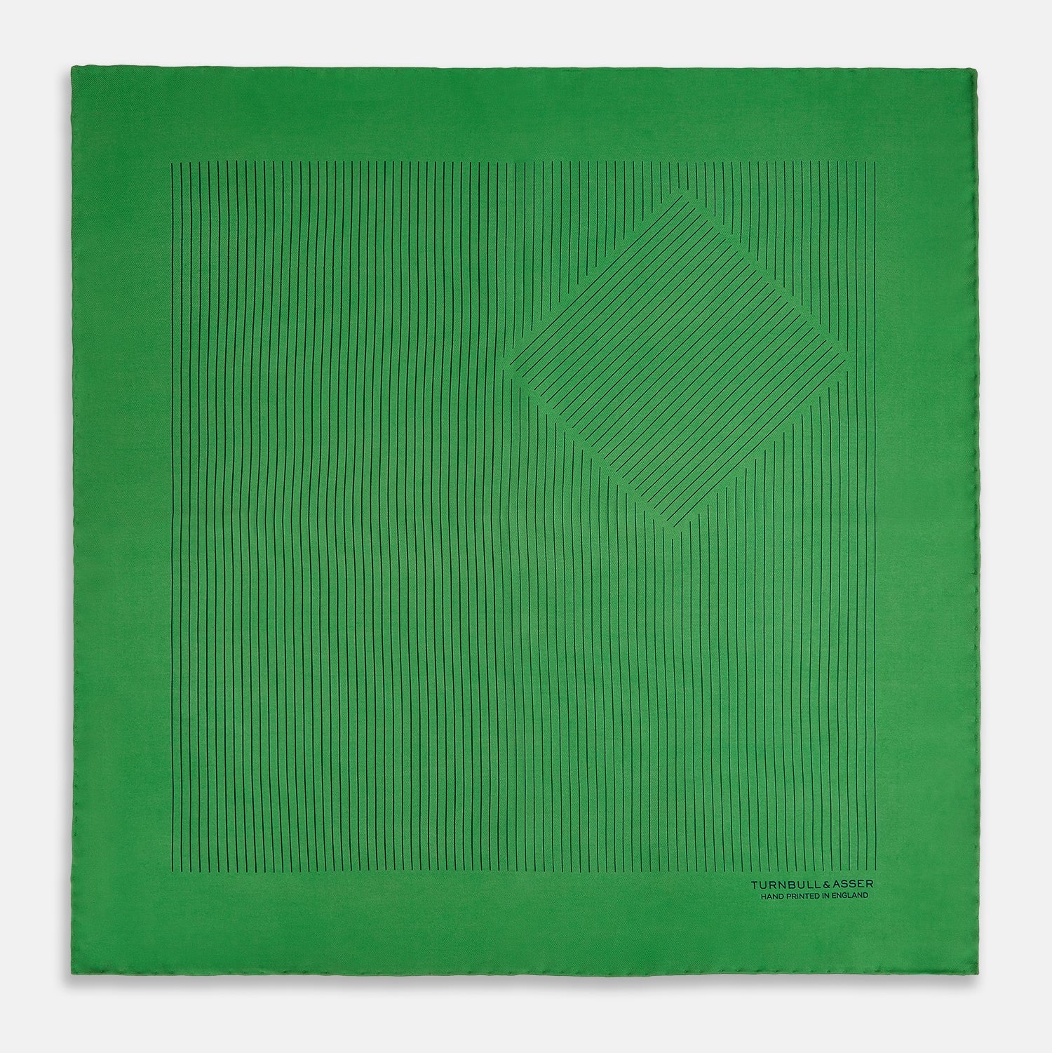View 3 of product The Hunter Green Stripe Silk Pocket Square by Turnbull & Asser features thin black vertical stripes on one corner and “Turnbull & Asser Hand Printed in England” printed in black, reflecting classic British heritage.