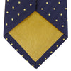 View 3 of product The Turnbull & Asser Navy Spot Woven Herringbone Silk Tie features a navy blue base with evenly spaced yellow polka dots, making it an essential accessory for smart attire. Displayed rolled on a white background.