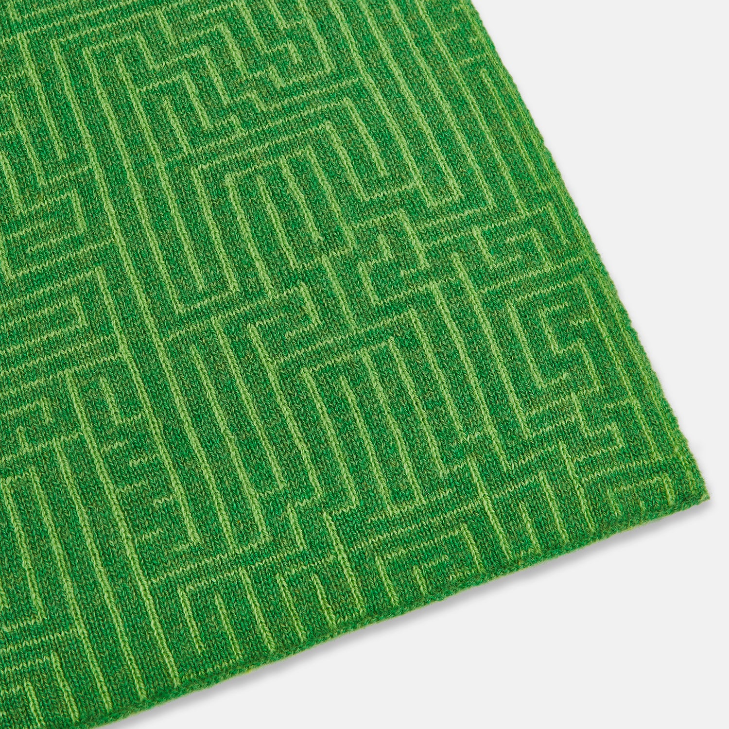 View 2 of product The Turnbull & Asser Kelly Green Fretwork Cashmere Knitted Scarf features a subtle, intricate pattern and is neatly knotted against a plain white background—an elegant accessory for any occasion.