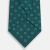 View 3 of product The Forest Green Medallion Silk Tie by Turnbull & Asser showcases a refined medallion pattern, offering an elegant, textured appearance. The tie is neatly rolled and displayed on a plain white background.