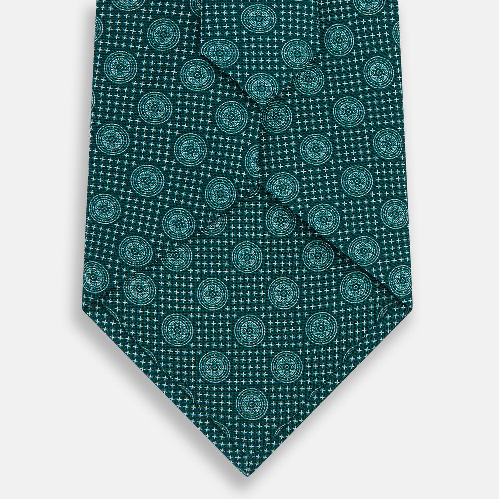 The Forest Green Medallion Silk Tie by Turnbull & Asser showcases a refined medallion pattern, offering an elegant, textured appearance. The tie is neatly rolled and displayed on a plain white background.