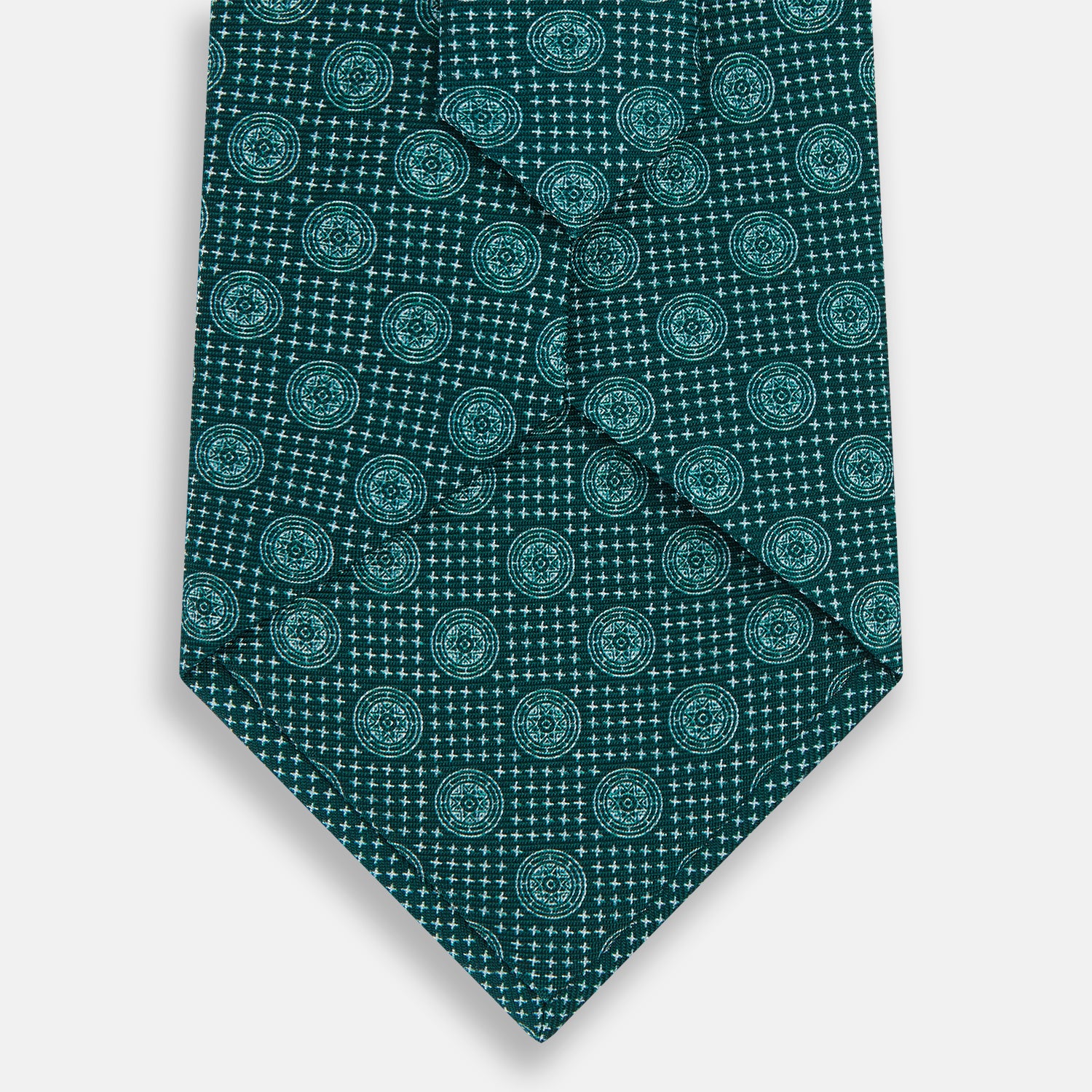 View 3 of product The Forest Green Medallion Silk Tie by Turnbull & Asser showcases a refined medallion pattern, offering an elegant, textured appearance. The tie is neatly rolled and displayed on a plain white background.