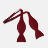 View 2 of product The Turnbull & Asser BURGUNDY SATIN BOW TIE features a deep red, smooth, and shiny finish—an essential accessory—neatly tied and showcased against a plain white background.