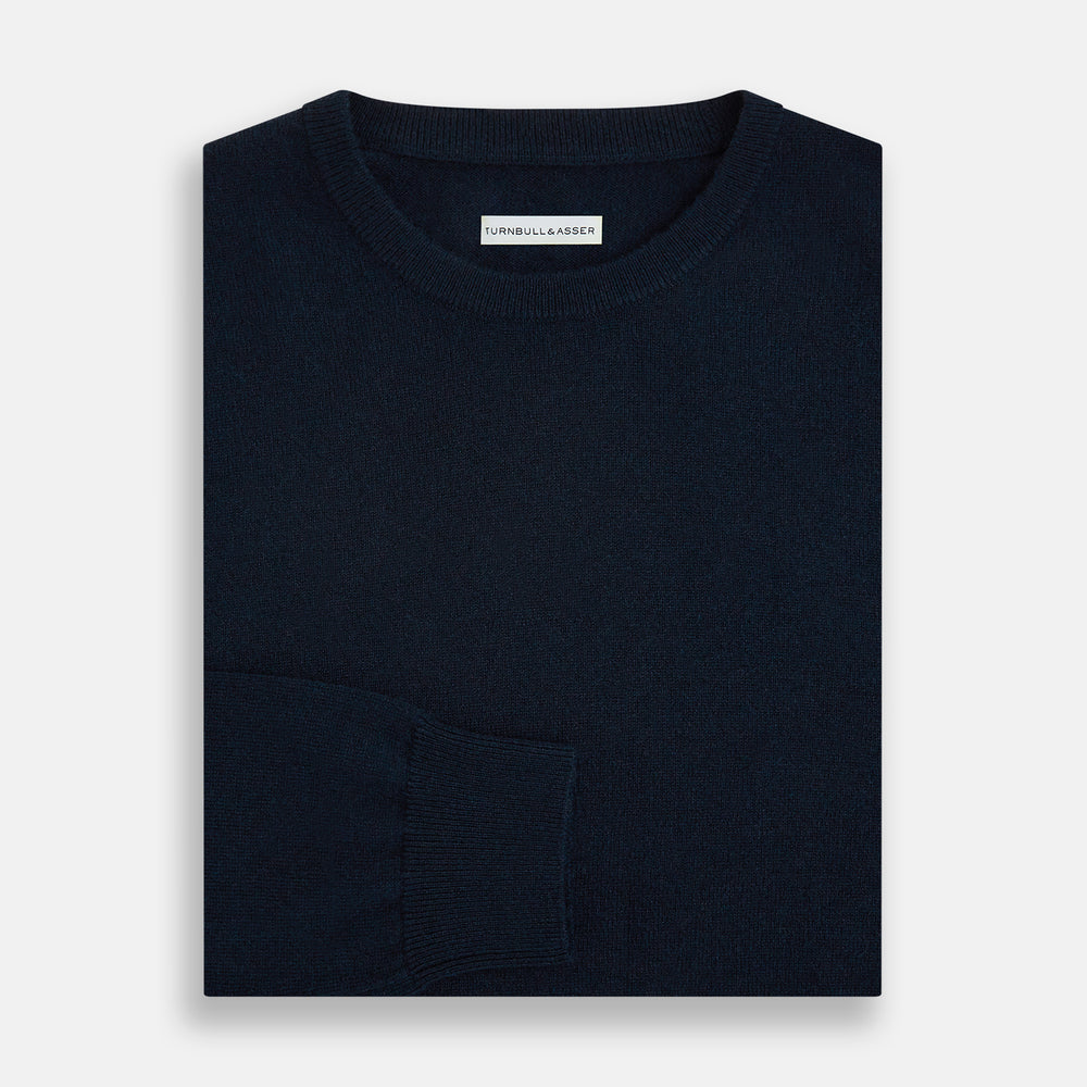 The Turnbull & Asser Navy Cashmere Round Neck Jumper for men is shown against a white background, featuring long sleeves, a relaxed fit, and ribbed cuffs, hem, and collar for an effortlessly elegant look.