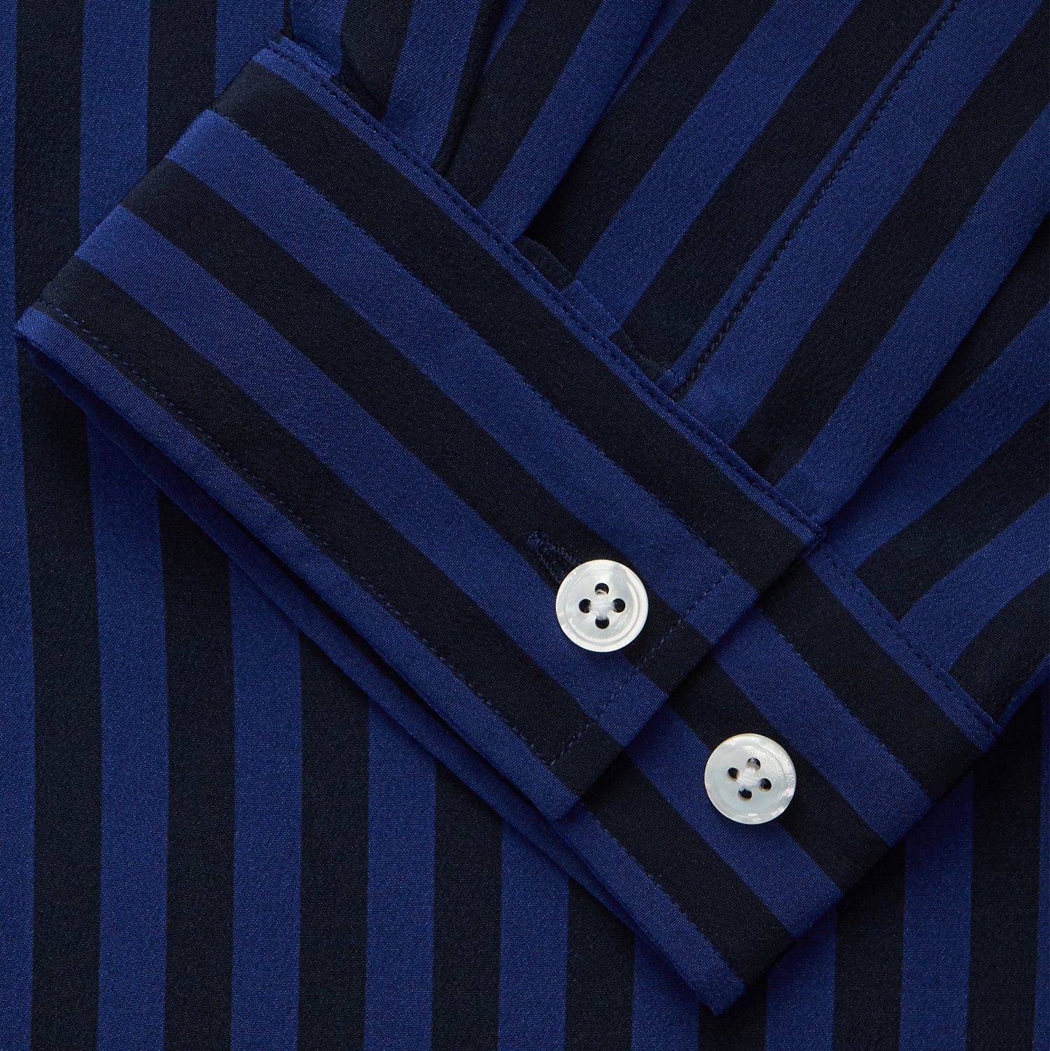 View 2 of product The Turnbull & Asser Navy and Blue Multi Stripe Silk Holiday Fit Winnington Shirt features white buttons, a notched collar, and a chest pocket, shown laid flat on a white background.