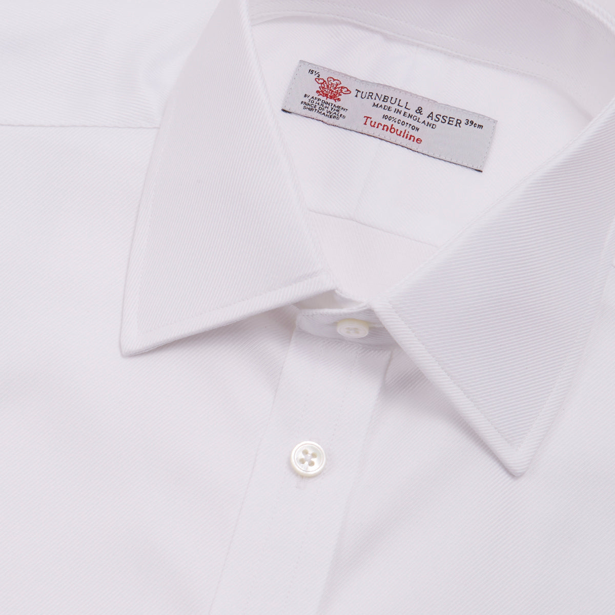 View 5 of product A neatly folded Turnbull & Asser White Oxford Shirt with T&A collar and double cuffs is displayed on a light blue background.