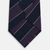 View 3 of product The Turnbull & Asser Purple And Navy Block Stripe Silk Blend Tie features dark navy and deep purple stripes with thin light gray lines, making it a refined formal accessory. Displayed on a white background.