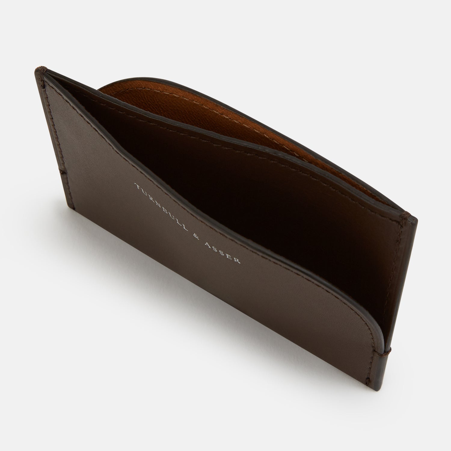 View 2 of product Crafted from dark chocolate leather, the Turnbull & Asser Slim Rounded Card Case features a curved right edge, clean stitching, and the brand’s white embossed logo.