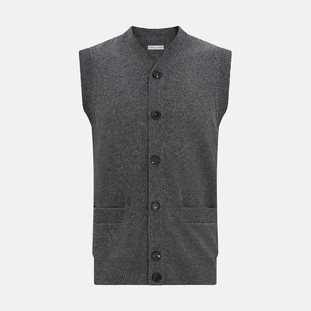 The Turnbull & Asser Charcoal Grey Cashmere Sleeveless Cardigan is a men's knit V-neck vest with ribbed collar, hem, and two front pockets, shown in dark grey melange against a white background.