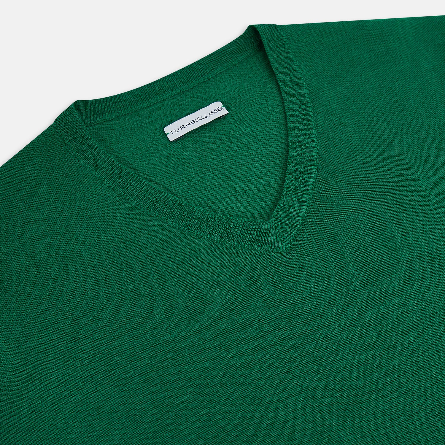 View 2 of product The Turnbull & Asser Hunter Green Fine Merino V-Neck Jumper is displayed against a white background, highlighting classic knitwear style.