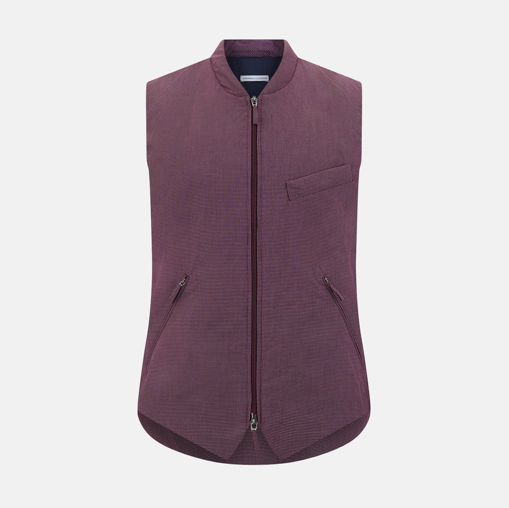 The Turnbull & Asser Burgundy Pin Check Padded Gilet features a front zipper, two zippered side pockets, a chest pocket, and a rounded hem—an ideal men’s layering piece shown on a white background.