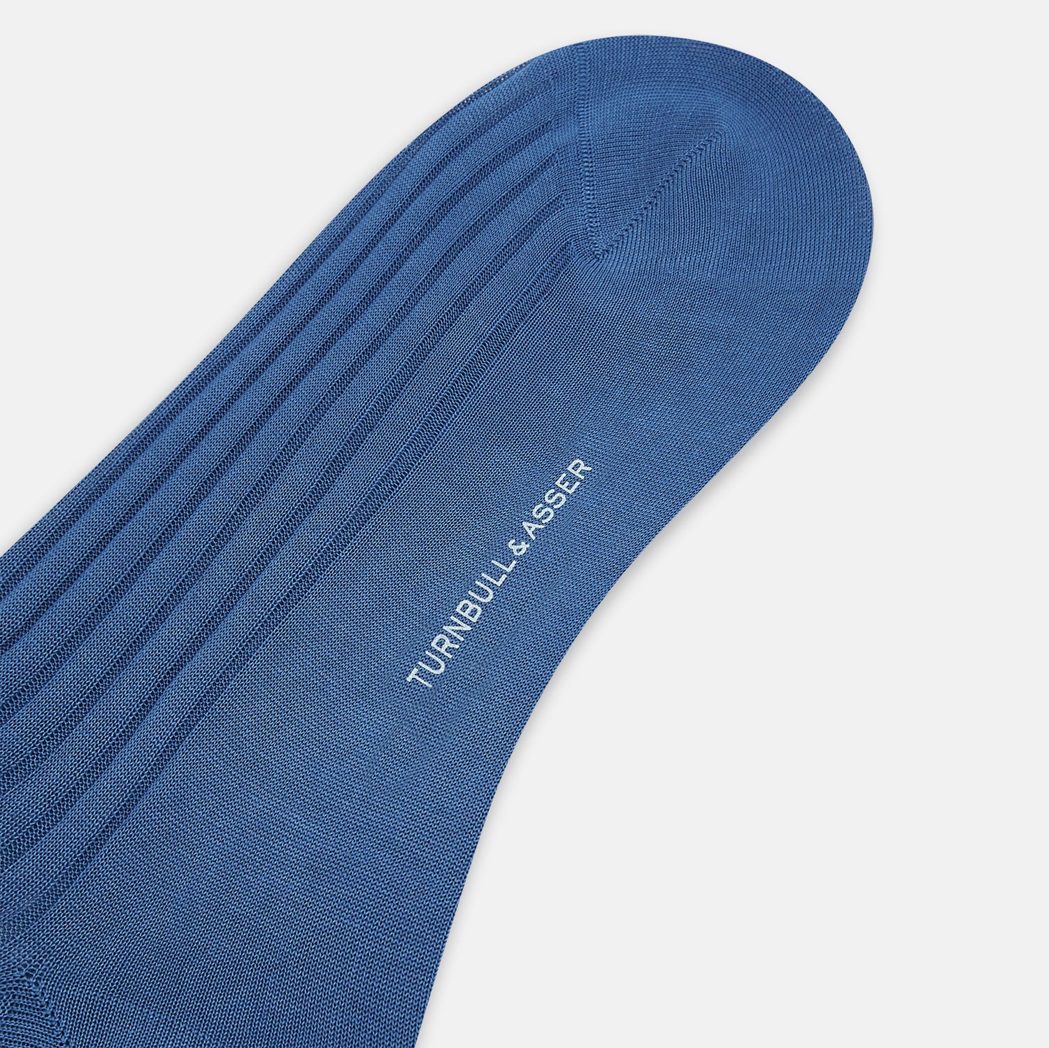 View 3 of product A single Azzurro Long Sock by Turnbull & Asser, in blue mercerised Egyptian cotton with a ribbed texture, is shown upright and angled left against a plain light background.