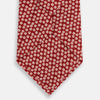 View 3 of product The Red Flower Patterned Silk Tie by Turnbull & Asser, crafted from fine English silk, features a delicate white floral design and is neatly rolled on a white background.