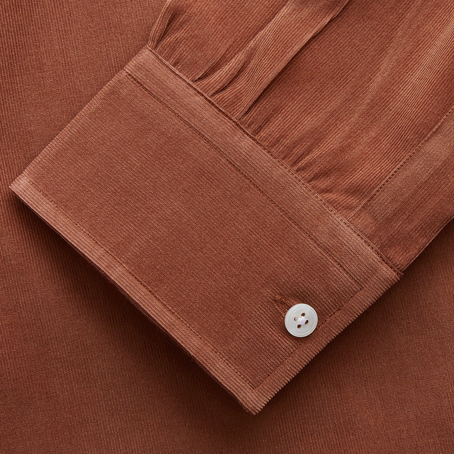 View 2 of product The Turnbull & Asser Rust Cotton Weekend Fit Blake Shirt features long sleeves, a stand collar, and white buttons—an ideal casual piece displayed flat on a white background.