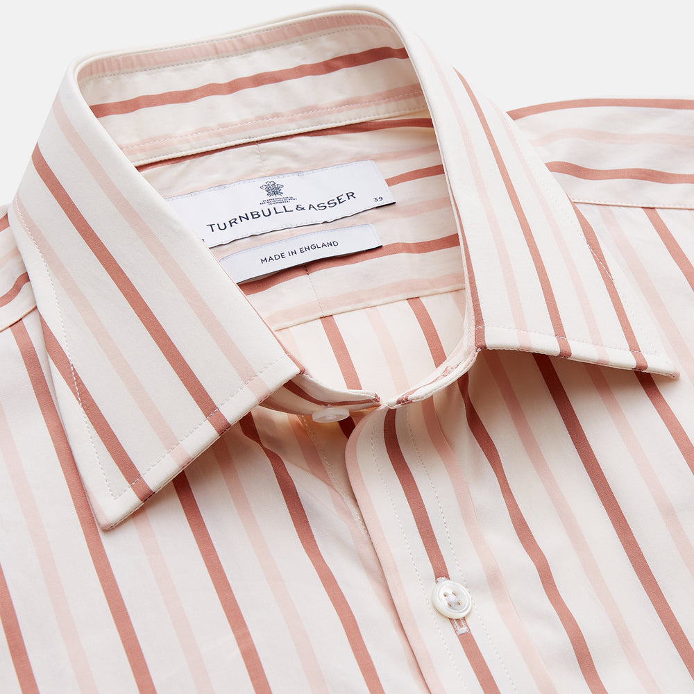 The Pink and Sandstone Stripe Cotton Regular Fit Mayfair Shirt by Turnbull & Asser features vertical pink and sandstone stripes on white, a T&A collar, wide cuffs, and a slightly curved hem for refined detail.