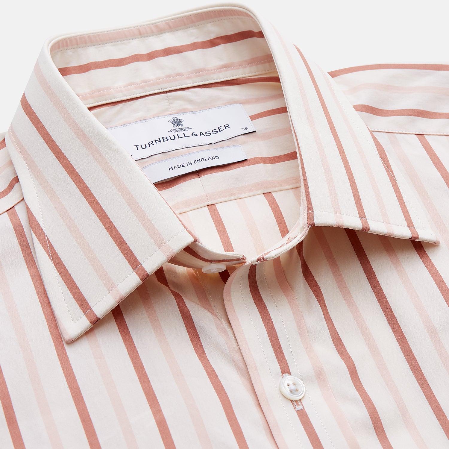 View 2 of product The Pink and Sandstone Stripe Cotton Regular Fit Mayfair Shirt by Turnbull & Asser features vertical pink and sandstone stripes on white, a T&A collar, wide cuffs, and a slightly curved hem for refined detail.