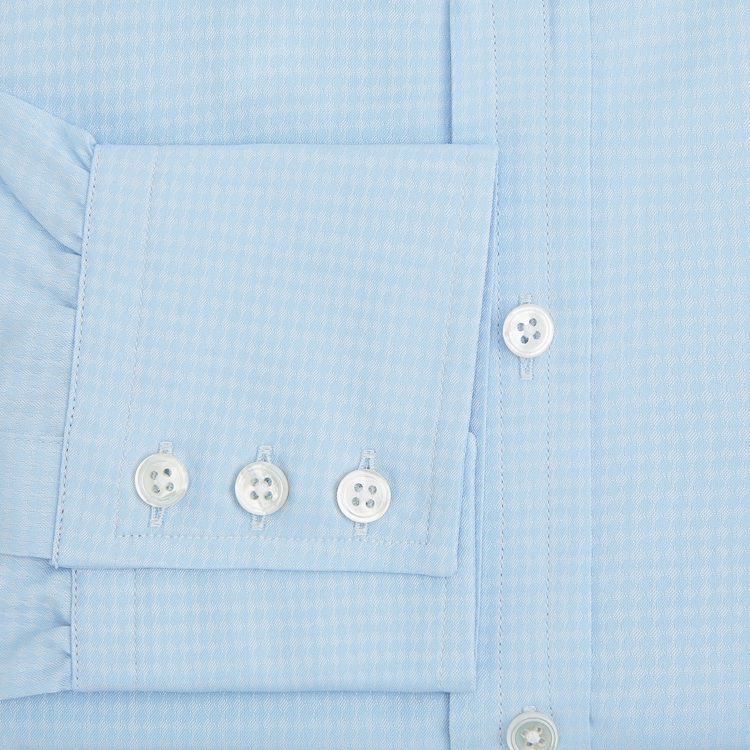 View 4 of product The Pale Blue Rhombus Mayfair Shirt by Turnbull & Asser features long sleeves, a classic collar, white buttons, and buttoned cuffs, shown laid flat on a white background.