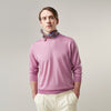 View 1 of product Wearing Turnbull & Asser’s Pink Merino Kingston Crew Neck Jumper, white pants, and a colorful scarf, a person stands against a plain light gray background with hands in their pockets.