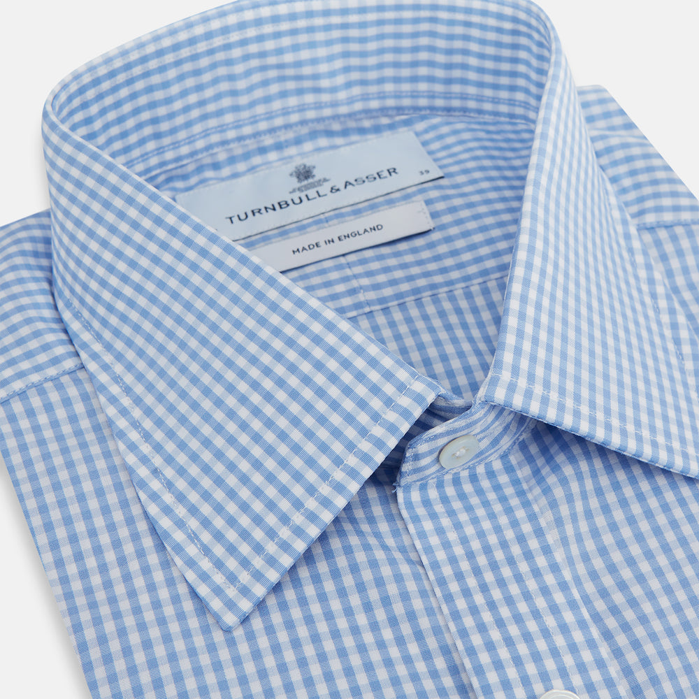The Turnbull & Asser Light Blue Gingham Check Shirt features a T&A collar, 3-button cuffs, classic gingham pattern, and white buttons down the front, shown laid flat on a white background.