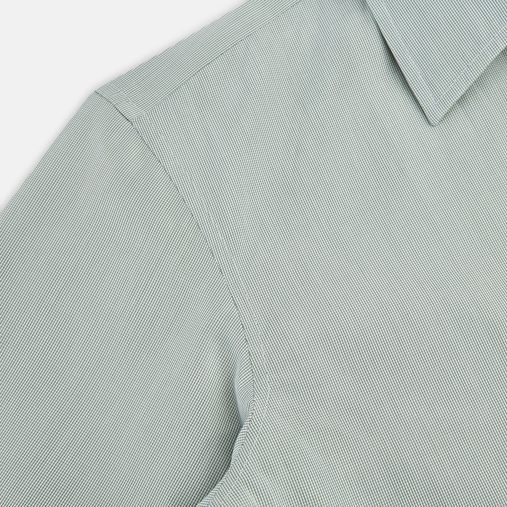 A dark green micro graph check Westminster shirt by Turnbull & Asser, featuring fine British craftsmanship, a Turnbull collar, and white buttons, is laid flat on a white background.