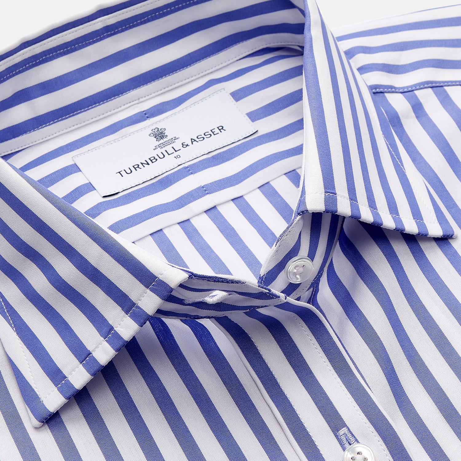 View 2 of product The Turnbull & Asser Pale Blue Candy Stripe Cotton Marlene Shirt is an oversized women's collared shirt with long sleeves, buttoned cuffs, and vertical blue and white stripes, shown laid flat on a white background.