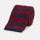 The Turnbull & Asser KNITTED STRIPE RED TIE features bold red and navy wide stripes in a rolled-up, knitted design—an eye-catching accessory shown on a plain white background.