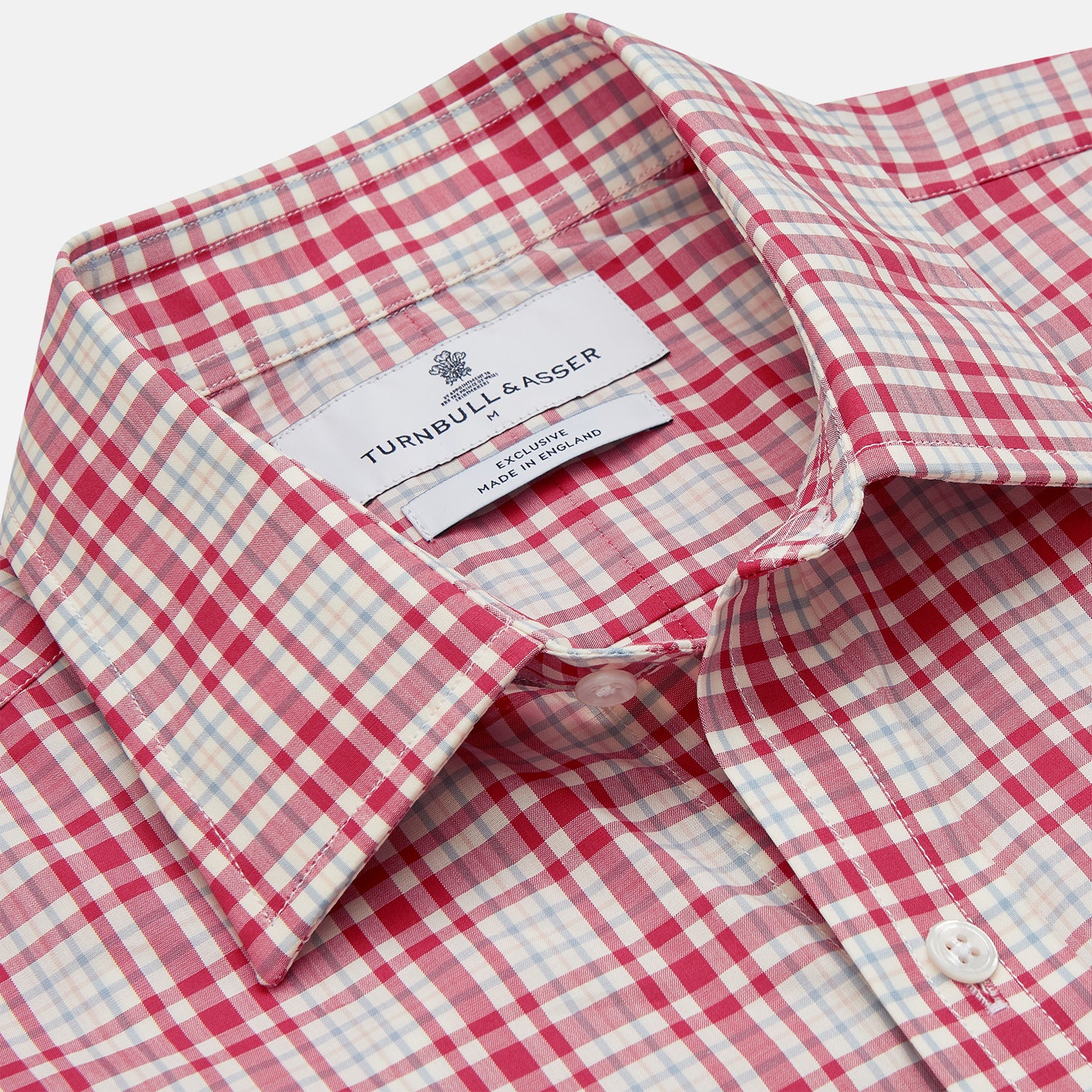 View 3 of product The Turnbull & Asser Red Check Cotton Weekend Fit Finch Shirt is a men's long-sleeved, button-up shirt with a Derby collar and red-and-white plaid pattern, displayed flat on a white background.