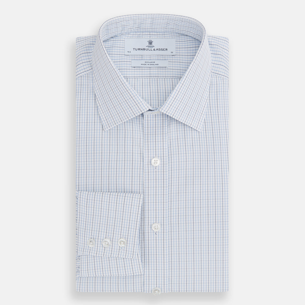 The Turnbull & Asser Pale Blue and Navy Grid Check Mayfair Shirt is a long-sleeve, button-up shirt made from fine Italian cotton, featuring a pointed collar and buttoned cuffs, shown against a plain white background.