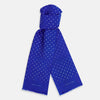 View 1 of product The Turnbull & Asser Royal Blue and White Spotted Silk Scarf features evenly spaced small white dots, fringed edges, and the brand’s name printed near the ends.