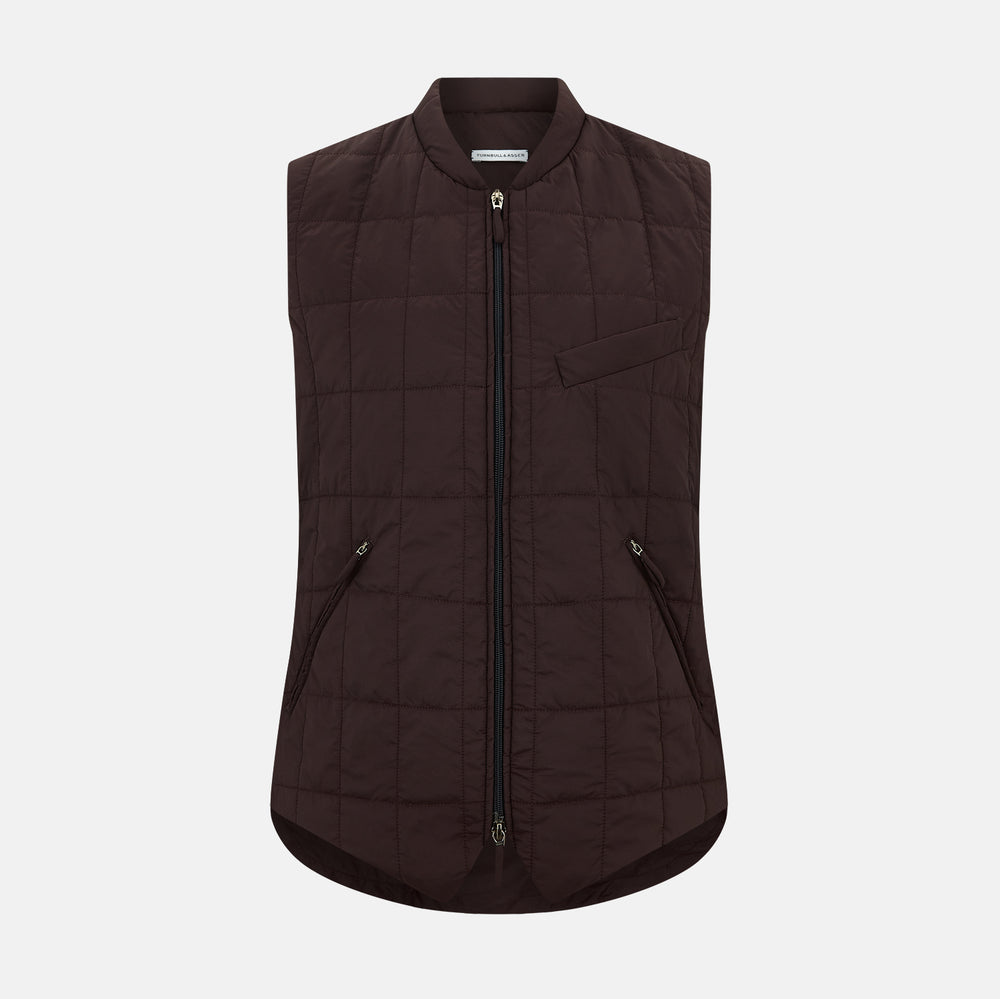 The Turnbull & Asser Burgundy Quilted Gilet is a sleeveless, lightweight layer featuring a front zipper, slanted chest pocket, adjustable side tabs, and two zippered side pockets, shown on a plain white background.