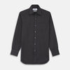 View 2 of product A man with short hair wears the Turnbull & Asser Black Check Weekend Fit Flannel Shirt with Derby Collar and 1-Button Cuffs, paired with light pants, against a plain background—ideal for a smart-casual weekend look.