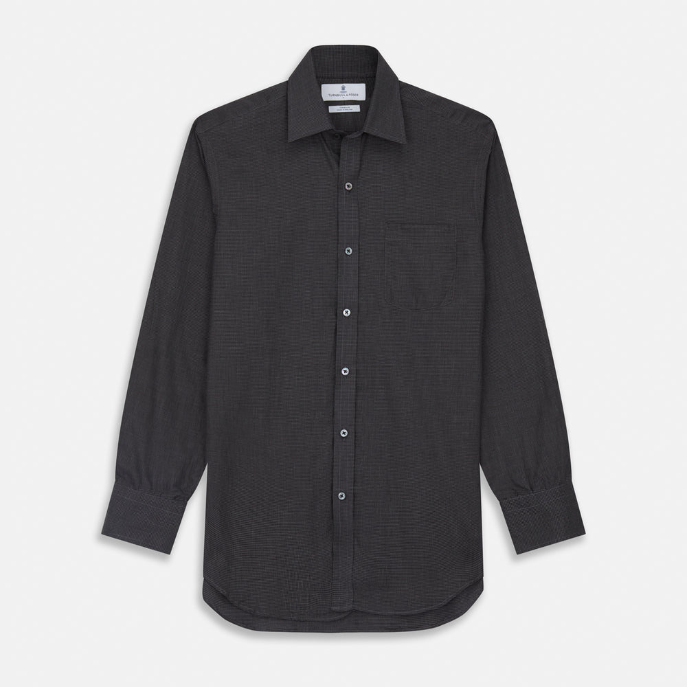 A man with short hair wears the Turnbull & Asser Black Check Weekend Fit Flannel Shirt with Derby Collar and 1-Button Cuffs, paired with light pants, against a plain background—ideal for a smart-casual weekend look.