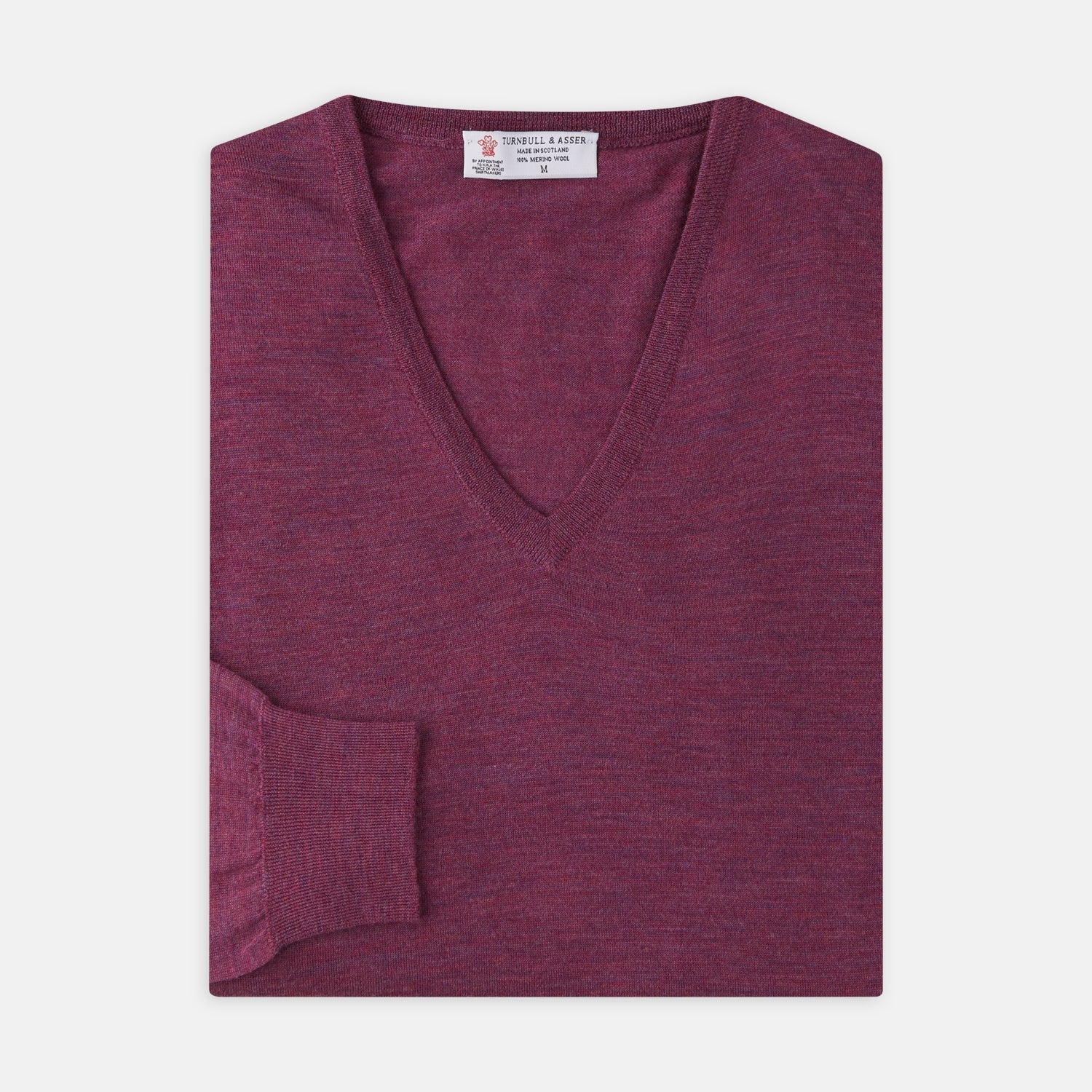 View 4 of product The Turnbull & Asser Plum Fine Merino V-Neck Jumper is a lightweight, long-sleeved layer in deep burgundy, featuring ribbed cuffs and hem for a refined finish, displayed against a white background.