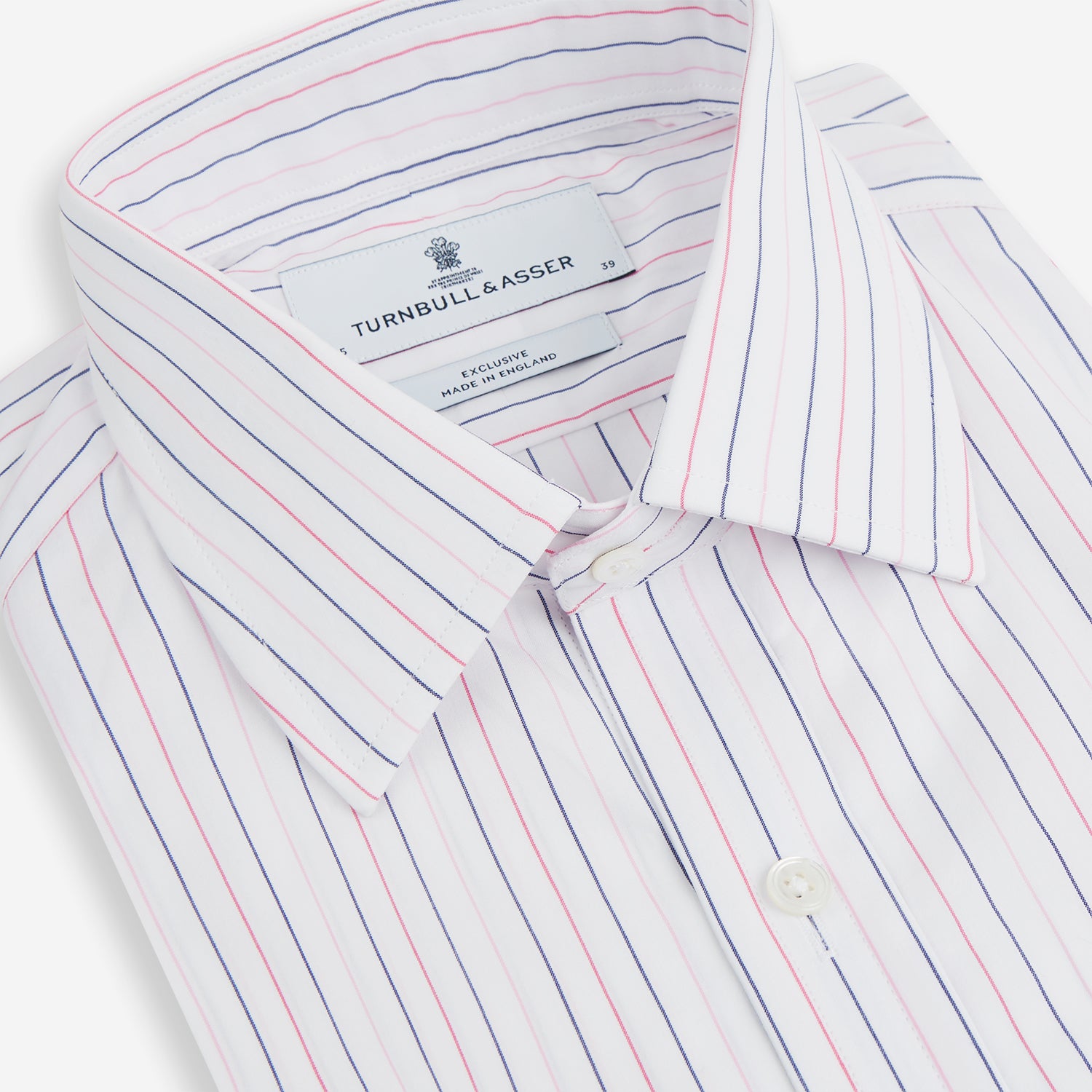 View 9 of product The Turnbull & Asser Pink and Blue Wide Pinstripe Mayfair Shirt features long sleeves, T&A collar, button-down front, and buttoned cuffs. It has bold pink and blue pinstripes on white and is laid flat on a white surface.