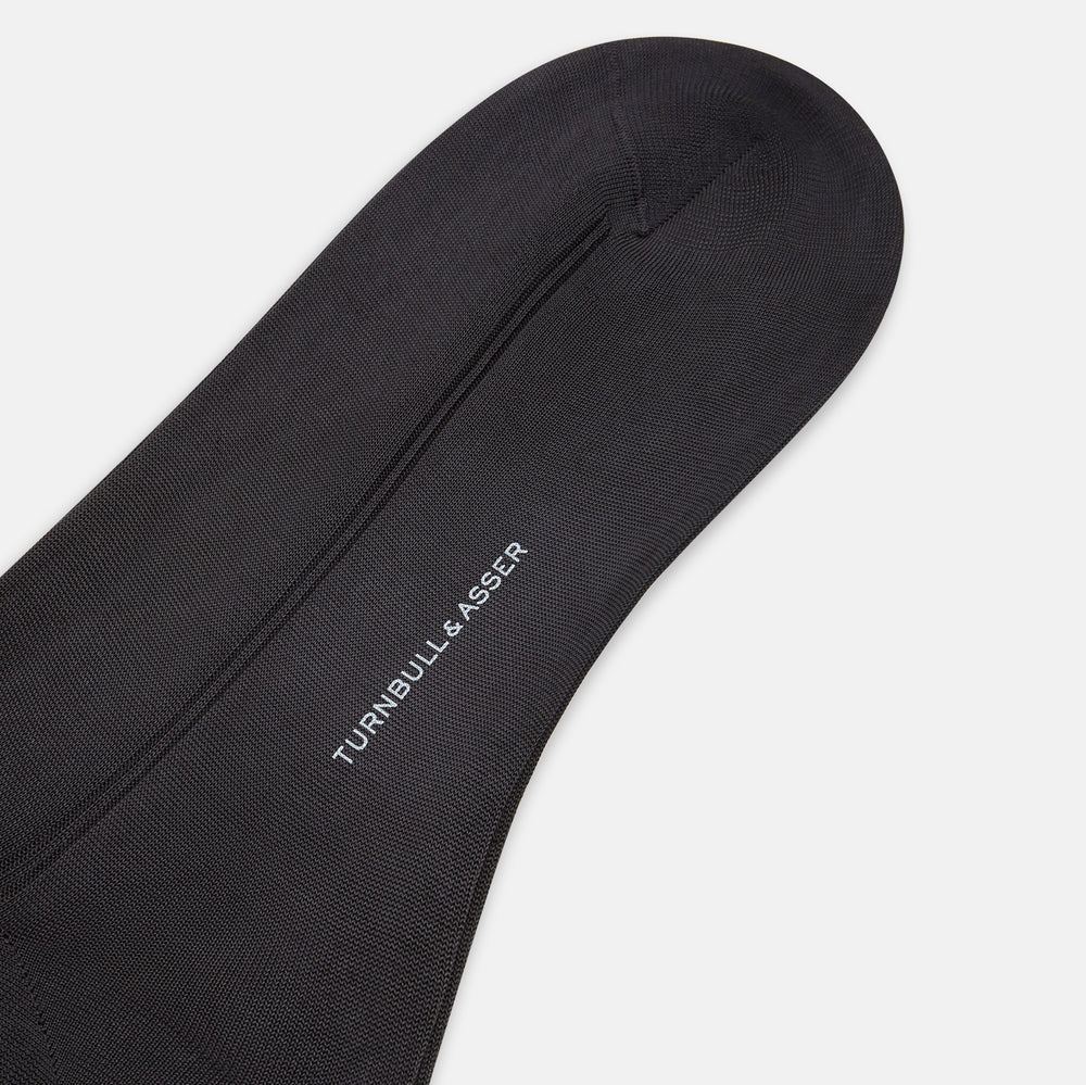 A single Sage Silk Long Sock by Turnbull & Asser, in black, is displayed from a side angle against a plain white background.